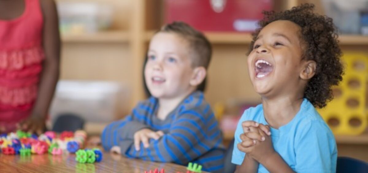 Preschool students laughing in class.