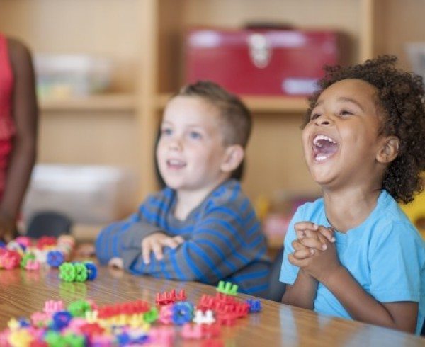 Preschool students laughing in class.
