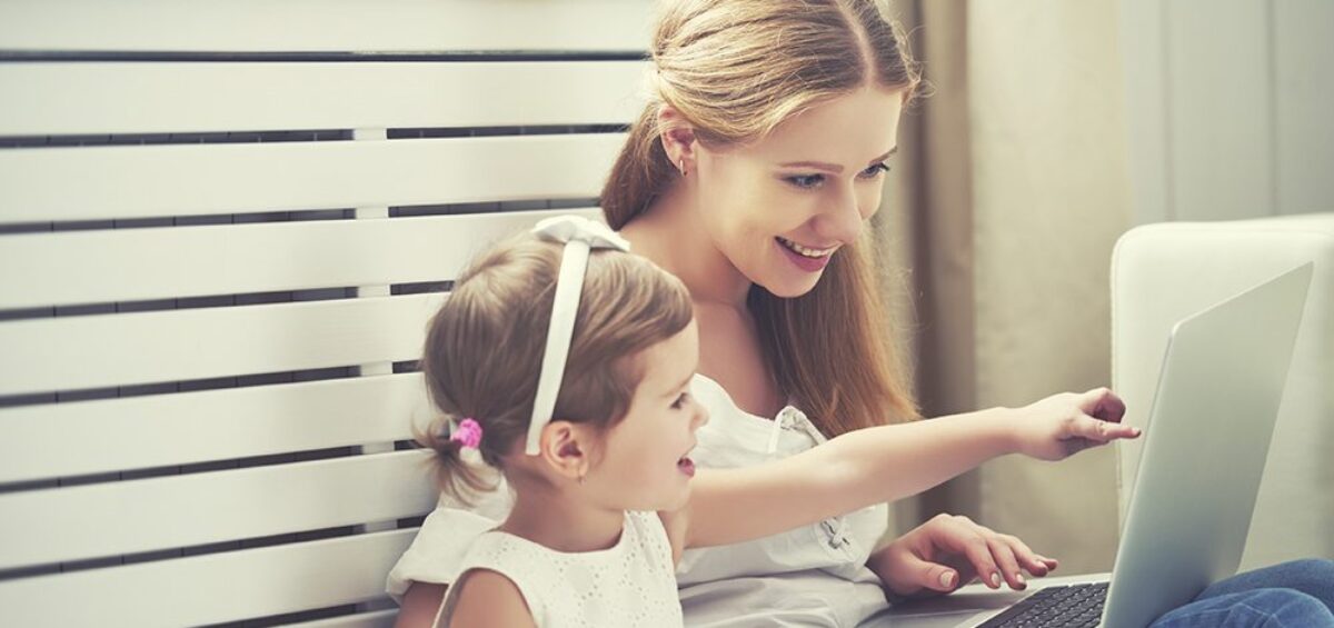 Mother and daughter pointing to laptop.