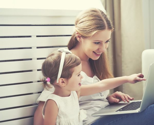 Mother and daughter pointing to laptop.