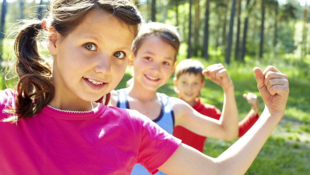 Two boys and a girl flexing their muscles.