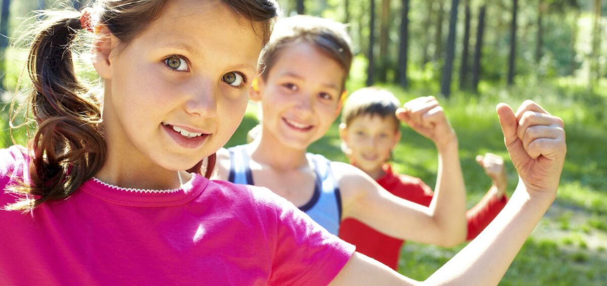 Two boys and a girl flexing their muscles.