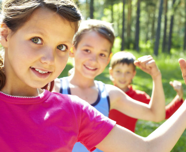 Two boys and a girl flexing their muscles.